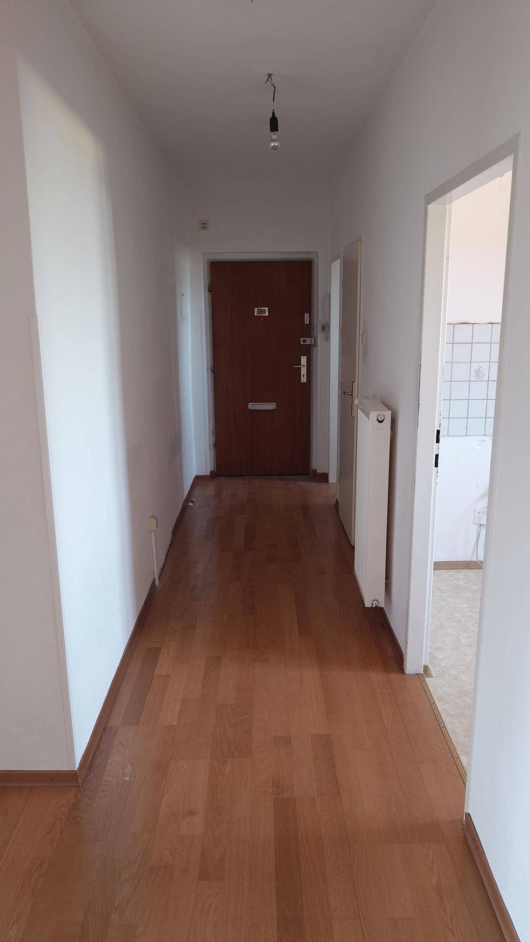 Eingangsbereich und Flur mit Parkettboden und Zugang zu weiteren Räumen.
