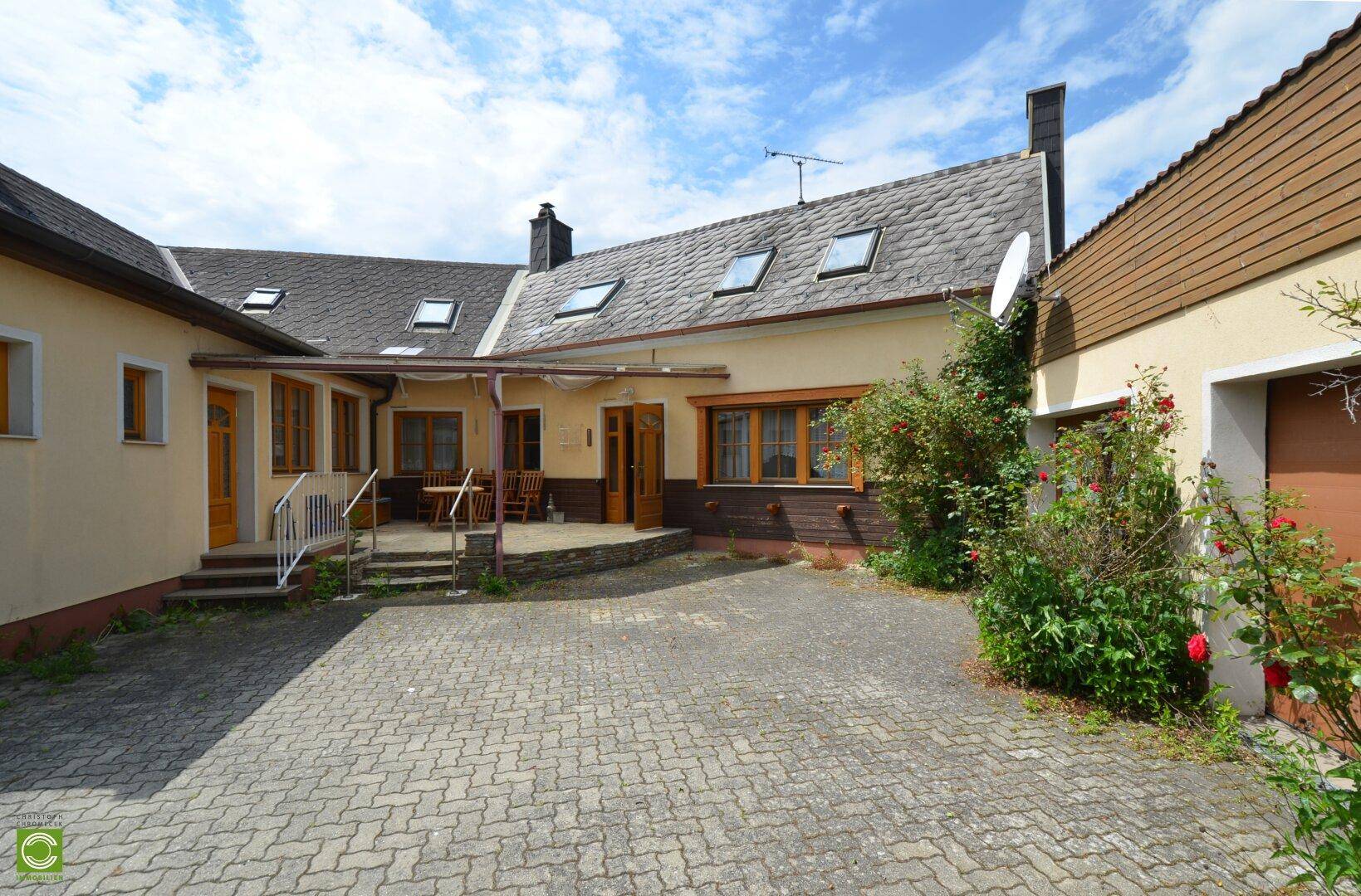 Hinterhof mit gepflastertem Bereich und überdachter Terrasse, ideal für entspannte Stunden im Freien.