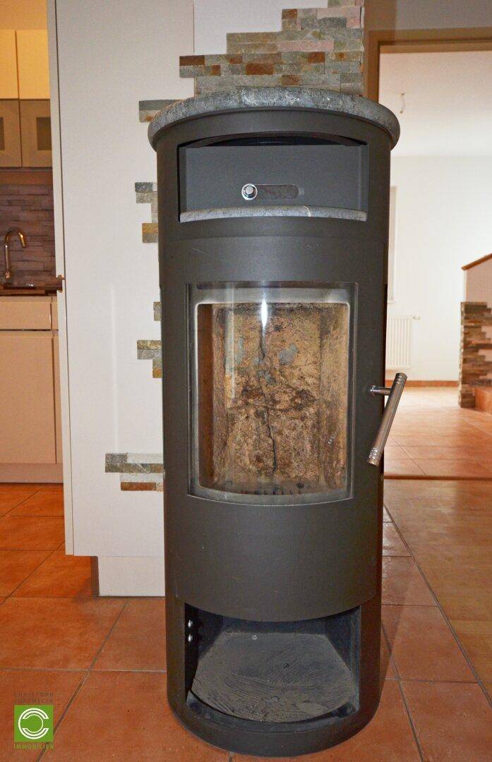 Moderner Kaminofen mit Steinverkleidung, der Wärme und Gemütlichkeit spendet.