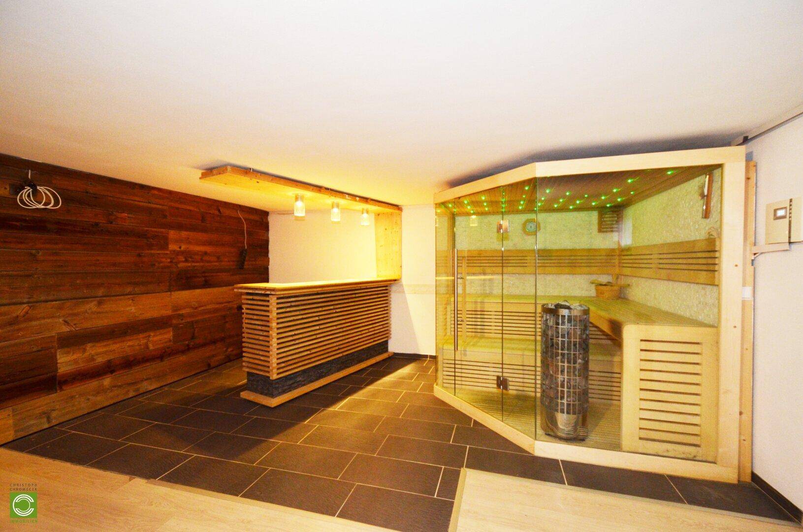 Wellnessbereich mit Sauna, Holzverkleidung und einer kleinen Bar.
