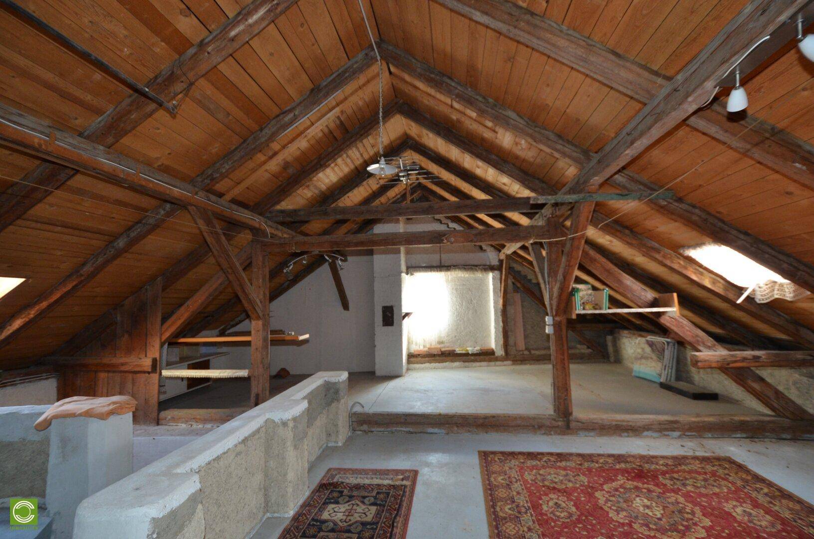 Ausgebauter Dachboden mit sichtbaren Holzbalken und Dachfenstern, bietet viel Potenzial.