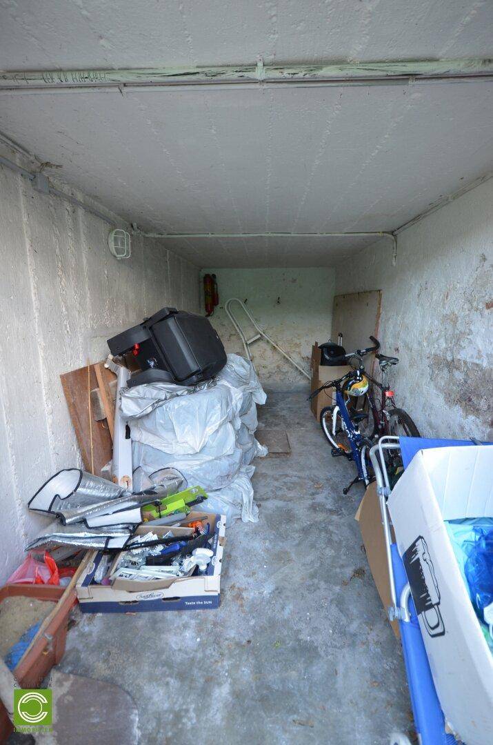 Geräumige Garage mit Betonboden, genutzt als Abstellraum für Fahrräder und andere Gegenstände.