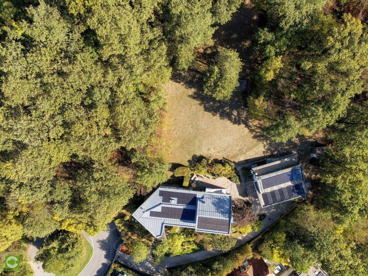 Luftaufnahme des Anwesens, eingebettet in eine weitläufige Waldlandschaft mit viel Grün.