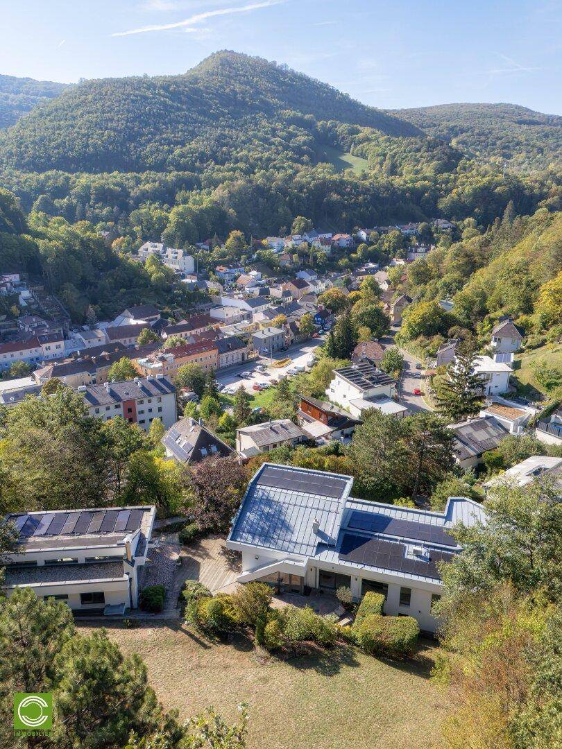 Weitläufiger Blick über das Anwesen und die darunterliegende Stadt, umgeben von grünen Hügeln.