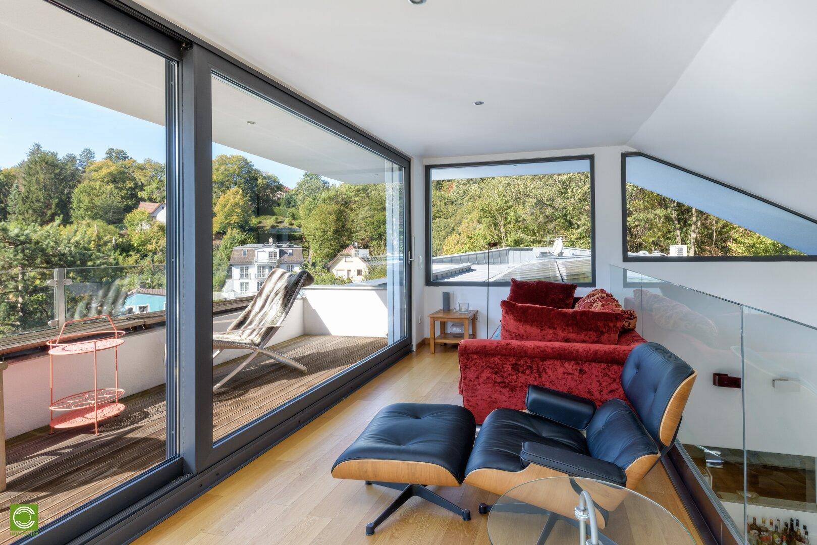 Gemütlicher Wohnbereich auf der Galerie mit Blick auf die umliegende Natur und den Balkon.