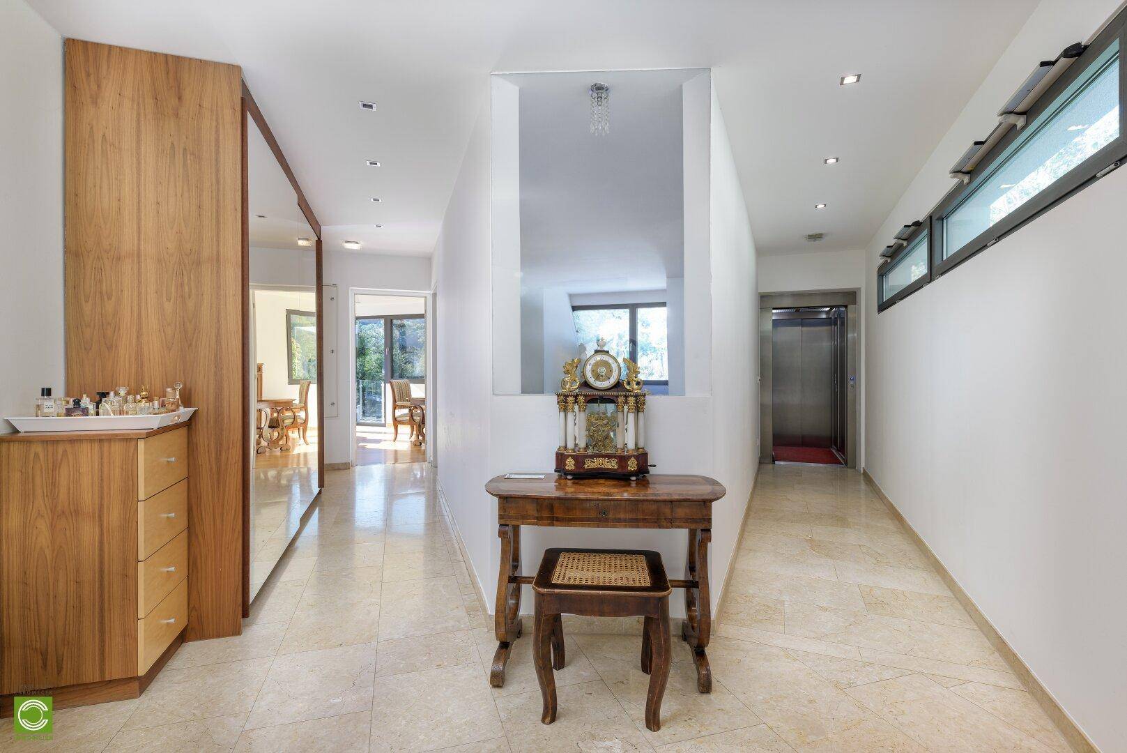 Geräumiger Eingangsbereich mit Aufzug, Spiegelschrank und eleganter Dekoration.