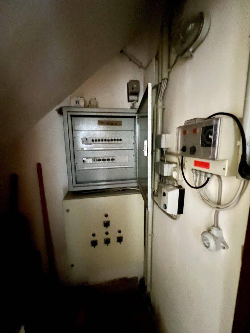 Elektrischer Sicherungskasten und Steuerungselemente in einem Technikraum.
