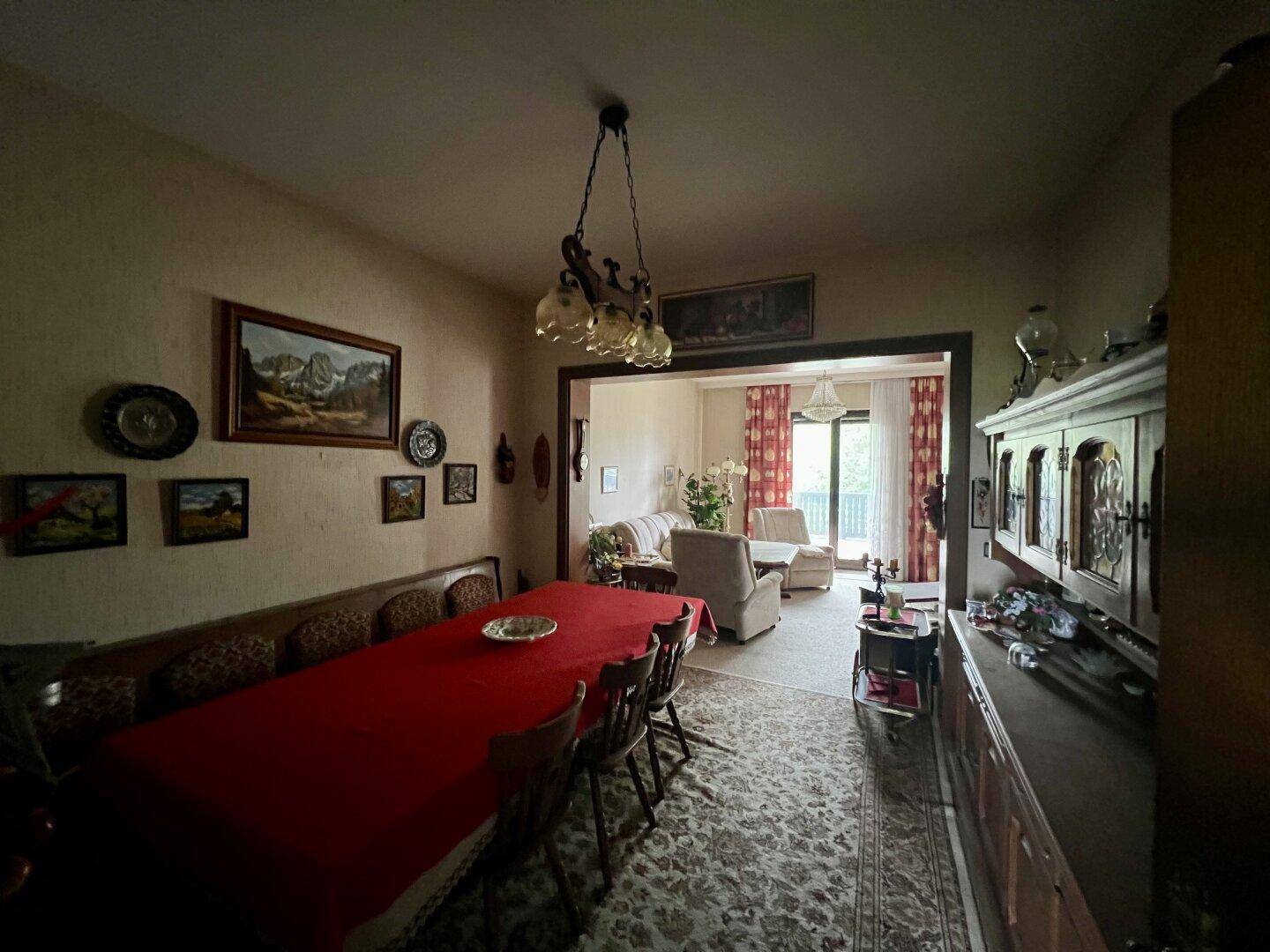 Essbereich mit großem Holztisch, Sitzbank und offenem Übergang zum Wohnzimmer.