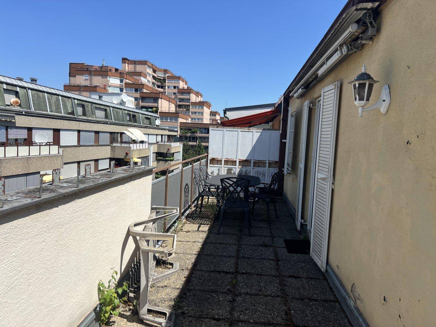 Möblierte Terrasse mit Sitzgelegenheiten und Blick auf die umliegende Stadtarchitektur.