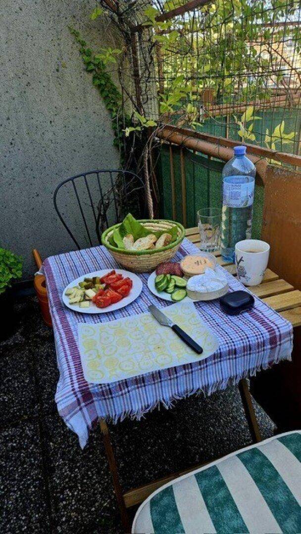 Gemütlicher Balkon mit kleinem Tisch und Stühlen, ideal für Mahlzeiten im Freien.