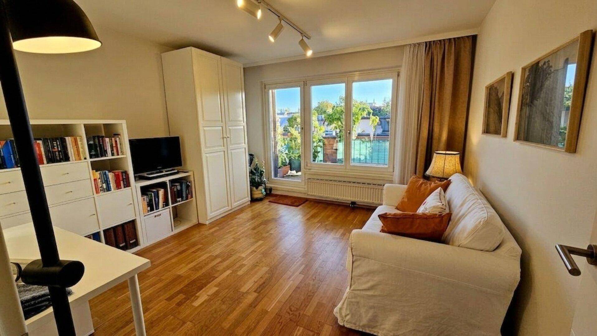 Gemütliches Wohnzimmer mit Zugang zu einem Balkon und viel Tageslicht.
