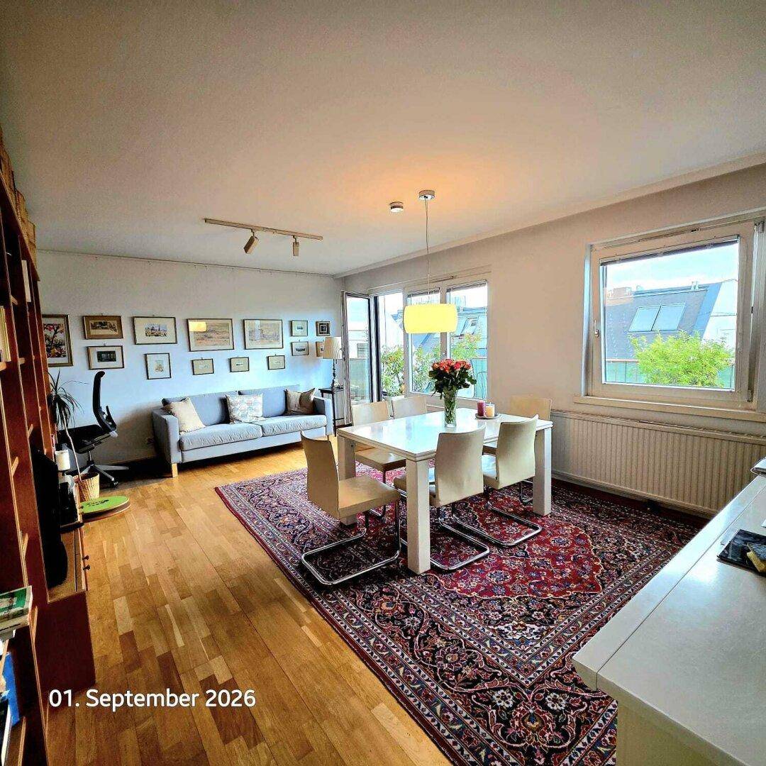 Heller Wohn-Essbereich mit Holzboden, großem Esstisch und gemütlichem Sofa, mit Blick ins Grüne.