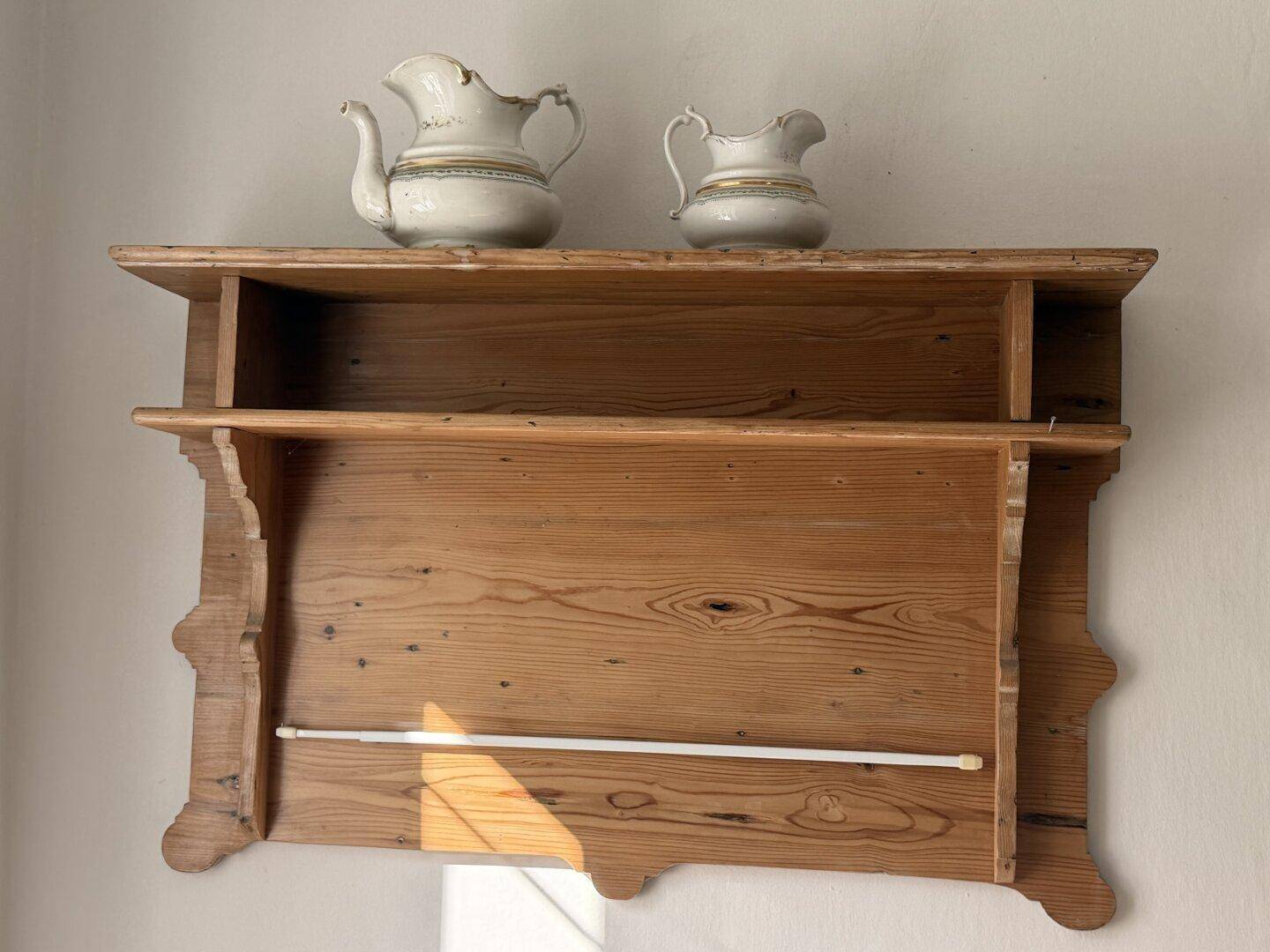 Rustikales Holzregal mit zwei dekorativen Keramikkrügen, ein charmantes Detail.