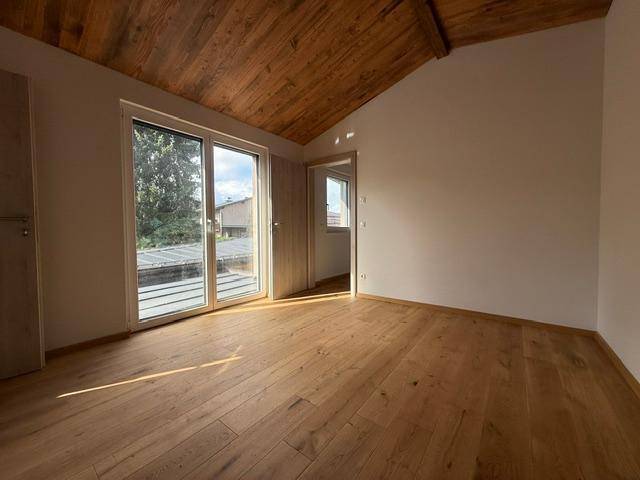 Helles Schlafzimmer mit Eichenparkett, Holzdecke und Zugang zu einem möglichen Balkon.