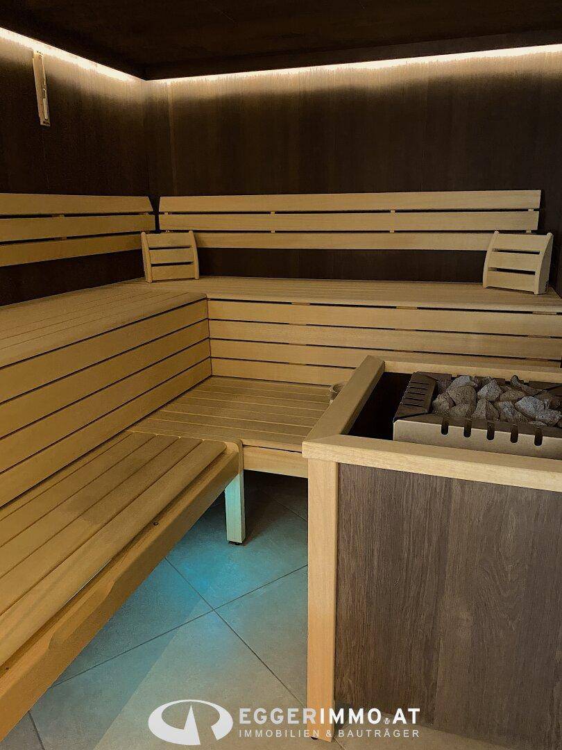 Gemütliche Holzsauna mit mehreren Bänken und einem Saunaofen für Entspannung.