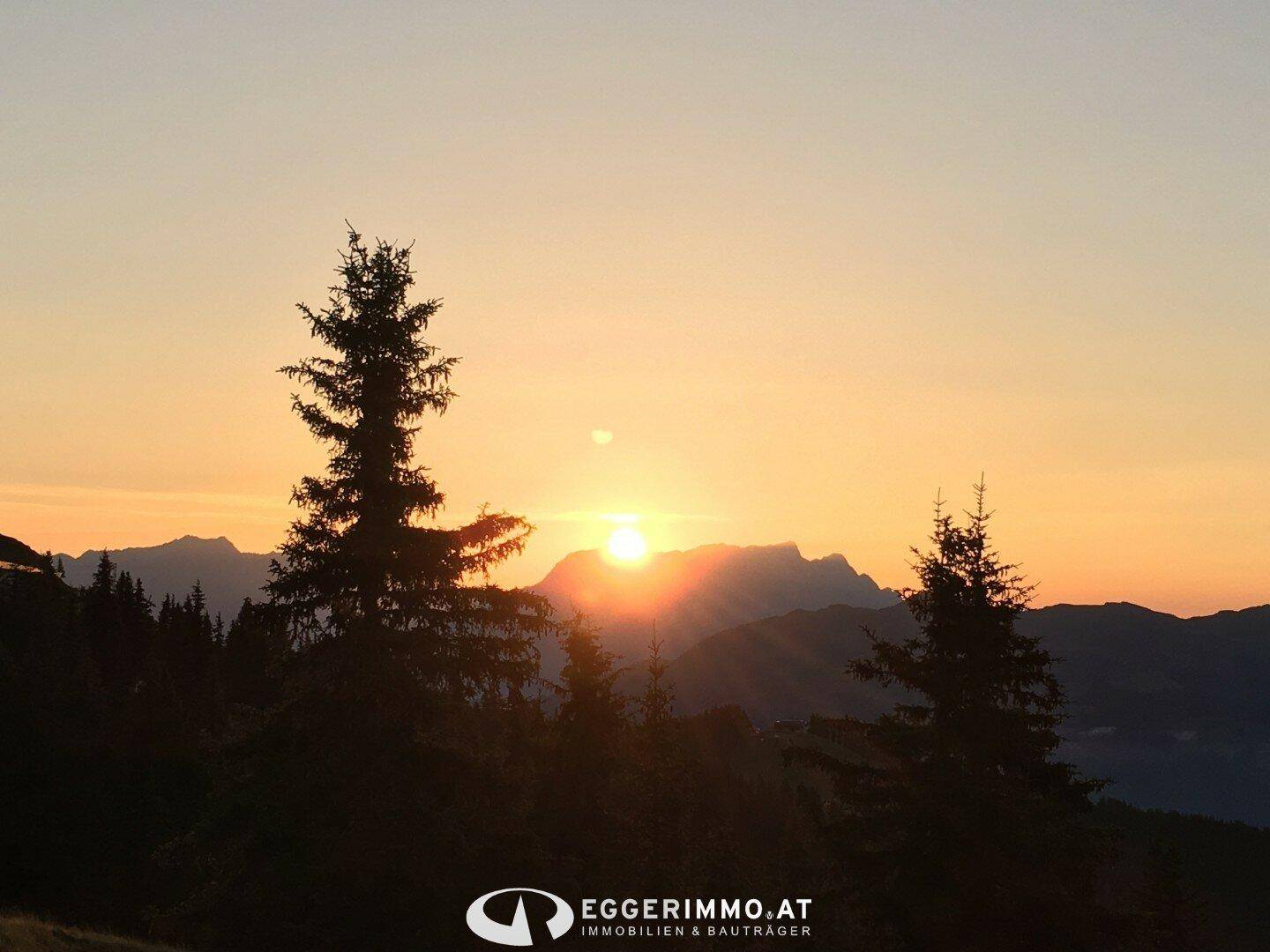 Malerischer Sonnenuntergang über den Bergen mit warmen Farben und ruhiger Atmosphäre.