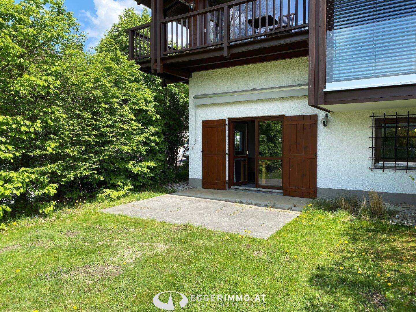 Kleine gepflasterte Terrasse am Haus mit Zugang zum Garten und Blick ins Grüne.