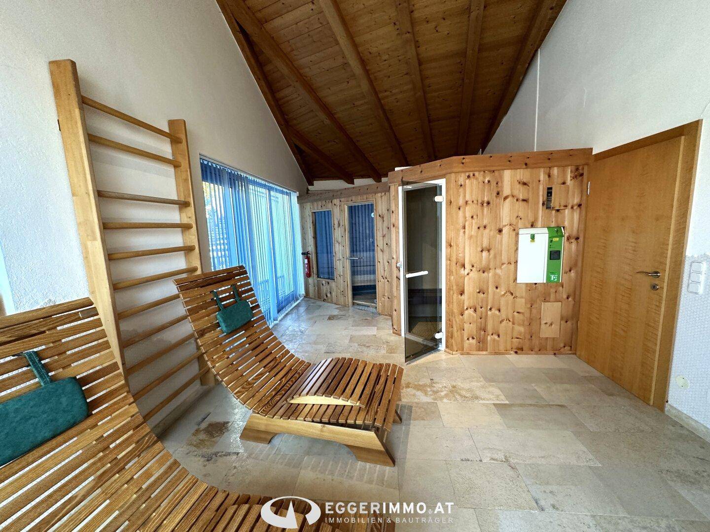 Entspannender Wellnessbereich mit Holzliegen und einer Saunakabine, ideal zur Erholung.