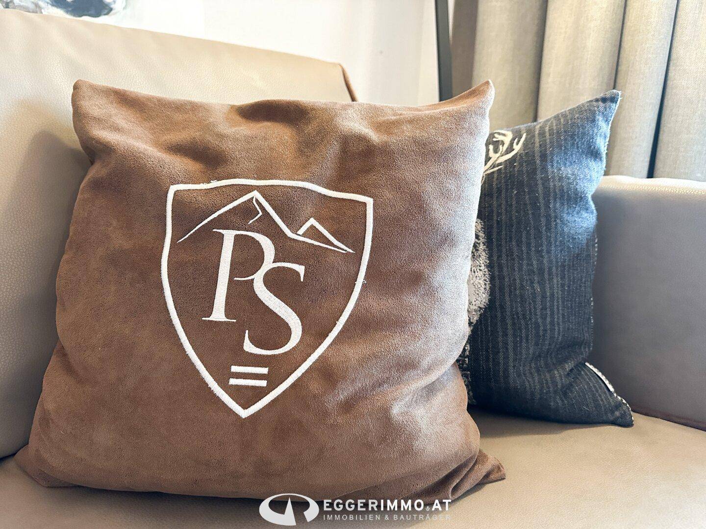 Detailaufnahme eines Kissens mit Bergmotiv, passend zum alpinen Stil der Einrichtung.