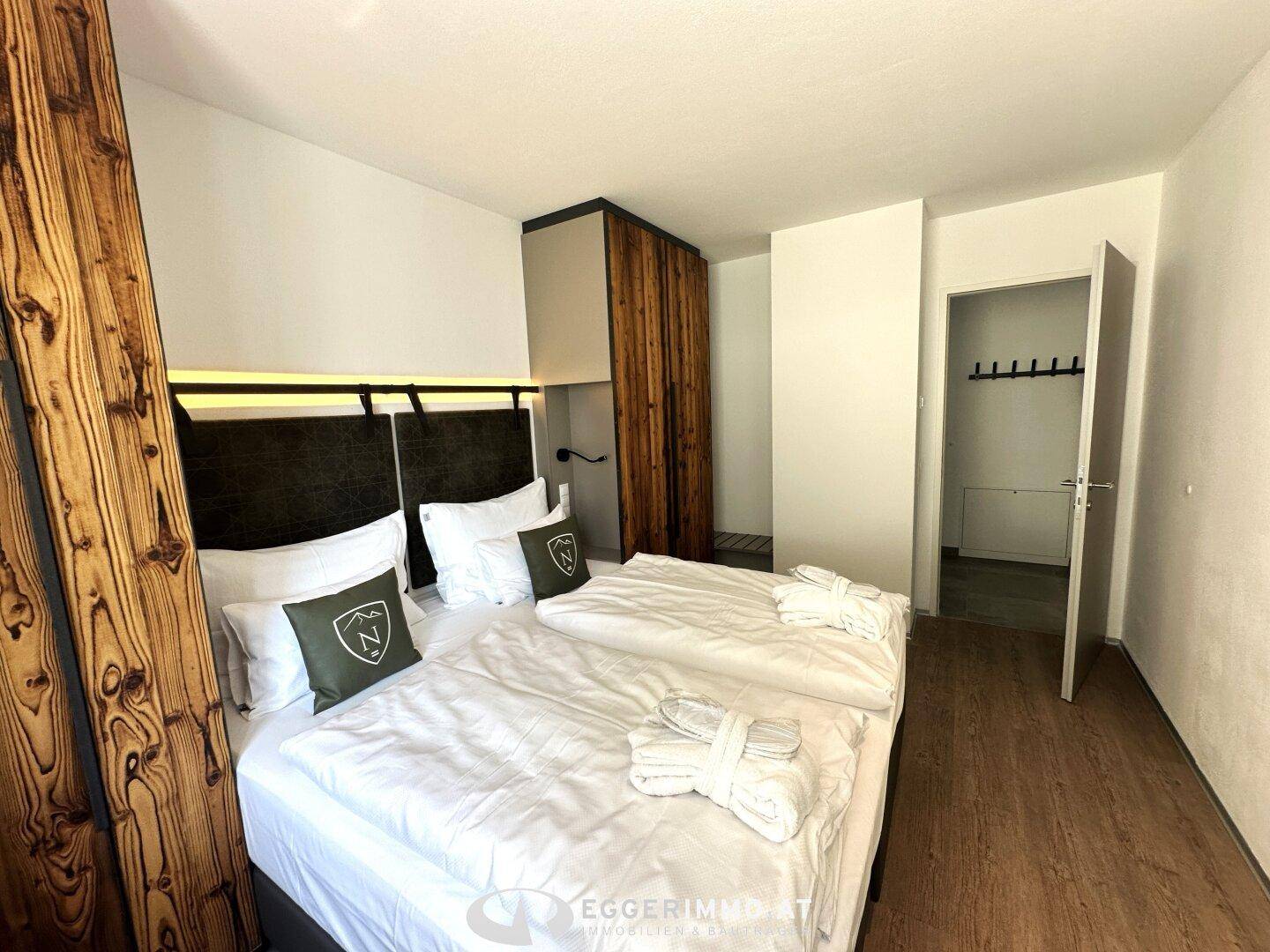 Helles Schlafzimmer mit komfortablen Betten und maßgefertigten Holzschränken, bietet viel Stauraum.