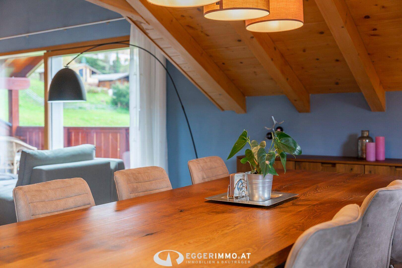 Geräumiger Essbereich mit großem Holztisch, bequemen Stühlen und Blick ins Wohnzimmer.