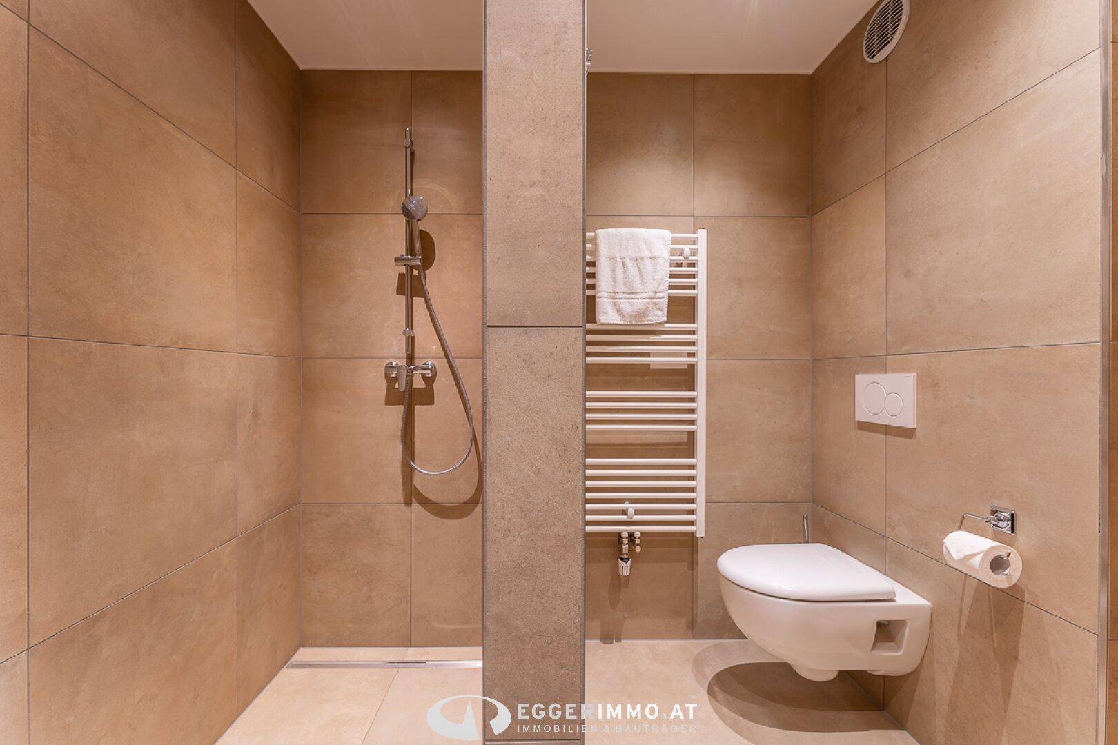 Modernes Badezimmer mit begehbarer Dusche, Hänge-WC und beheiztem Handtuchhalter.