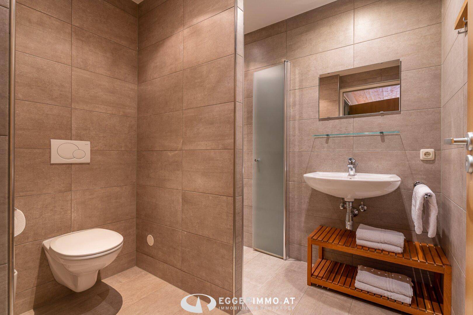 Modernes Badezimmer mit Waschbecken, Spiegel und Hänge-WC.