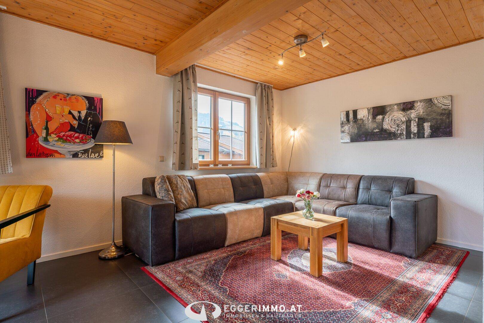 Gemütlicher Wohnbereich mit großem Ecksofa, Couchtisch und dekorativem Teppich.