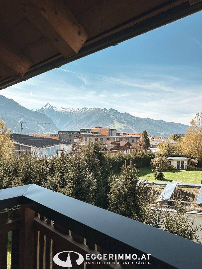 Sonniger Holzbalkon mit weitem Blick auf die Berge und die umliegende Natur.