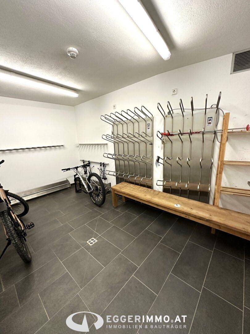 Funktionaler Skiraum mit Regalen für Skier und Skischuhe sowie Fahrradstellplätzen, sehr praktisch.