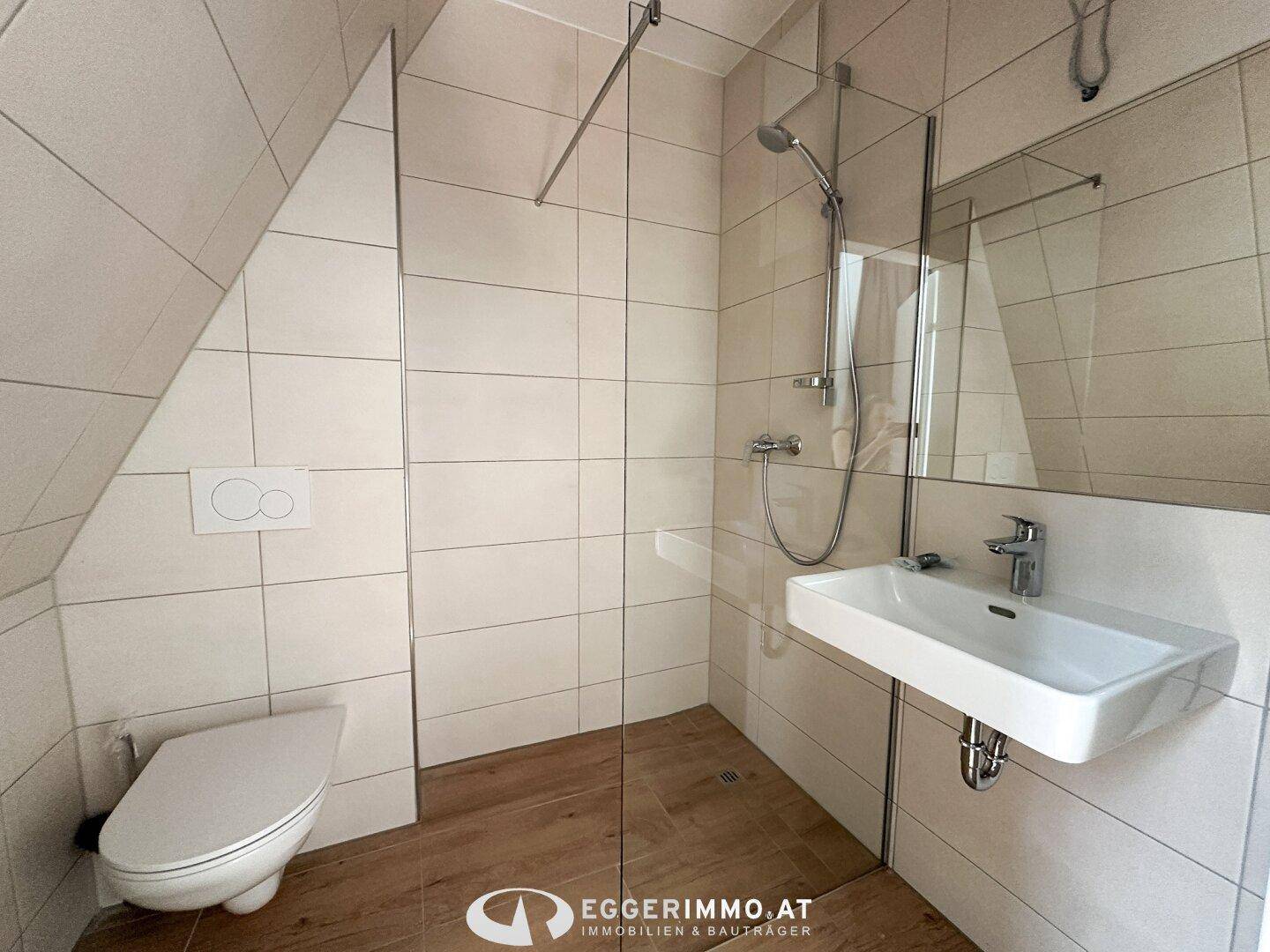 Modernes Badezimmer im Dachgeschoss mit ebenerdiger Dusche, Wand-WC und Schrägdach.