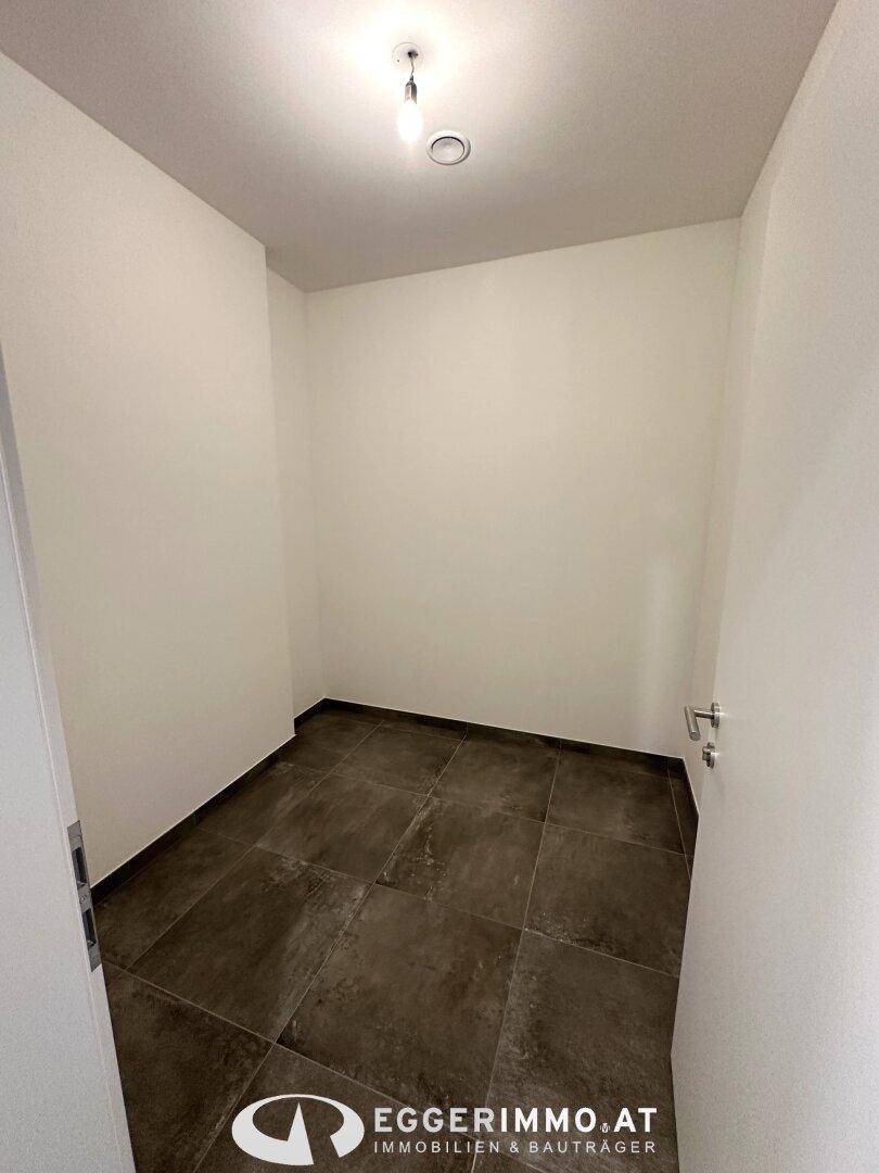 Kleiner Abstellraum mit Fliesenboden und weiß gestrichenen Wänden, ideal für zusätzlichen Stauraum.