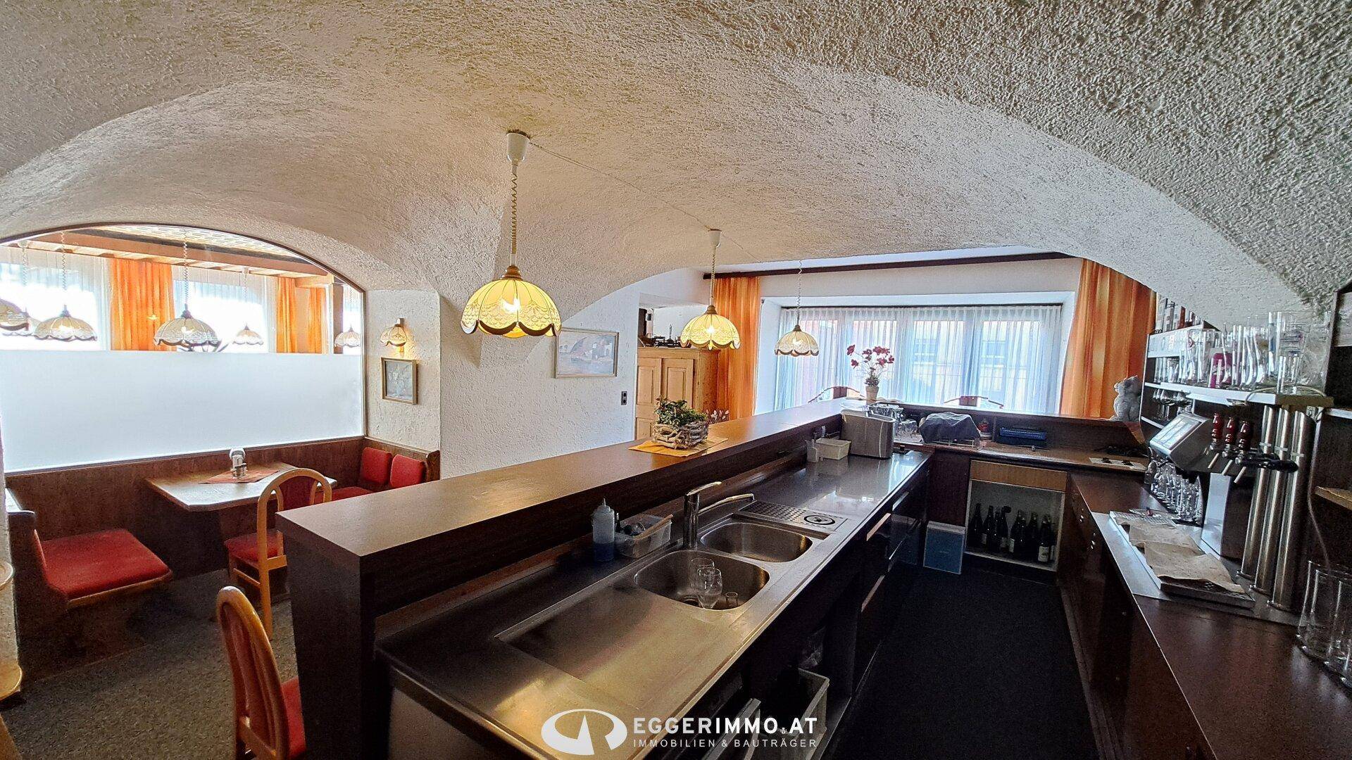 Bar- und Thekenbereich mit Spülbecken, Kühlschränken und traditioneller gewölbter Decke.