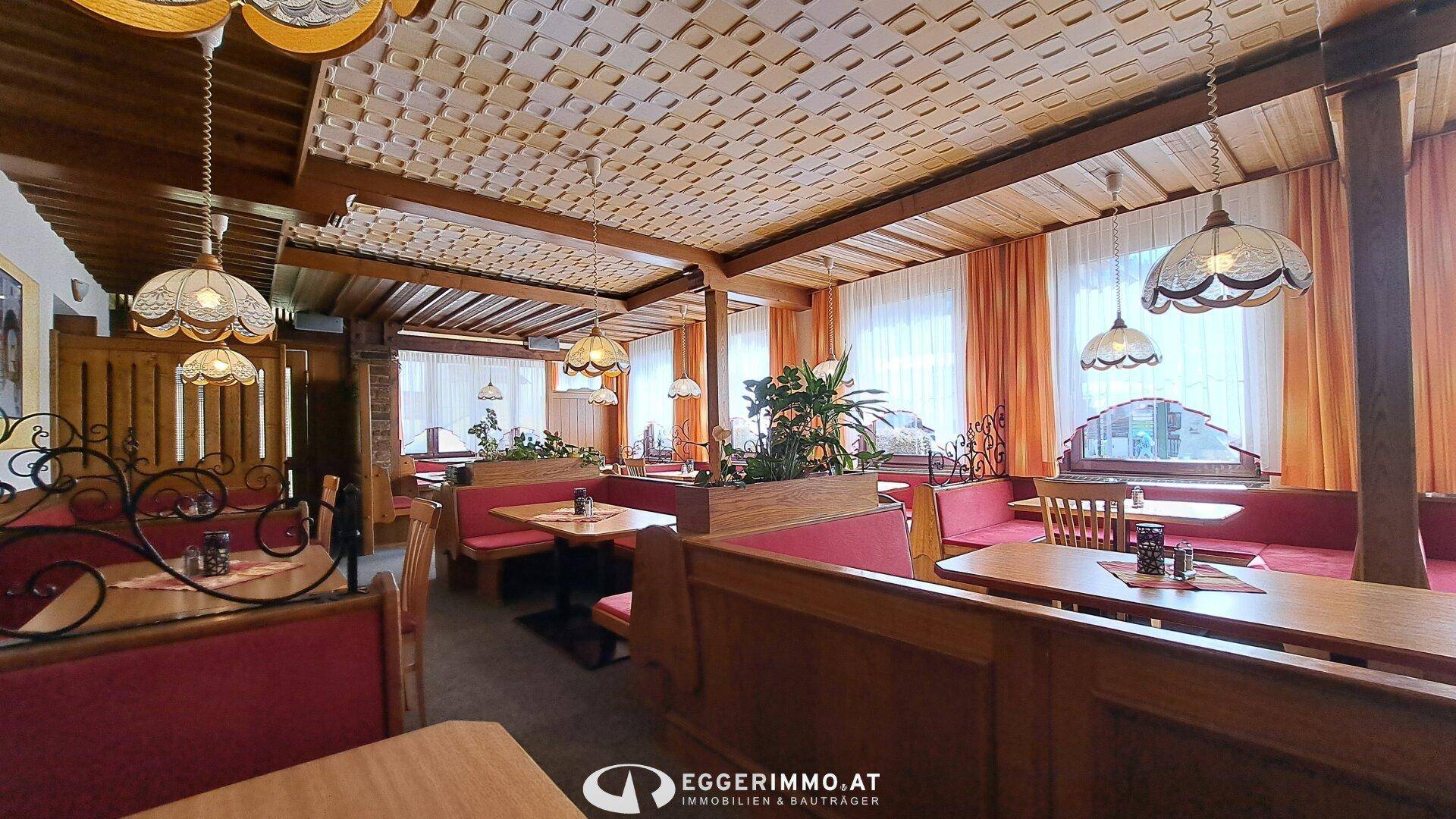 Weitläufiger Restaurantbereich mit vielen Sitzgelegenheiten, Holzelementen und traditionellen Lampen.