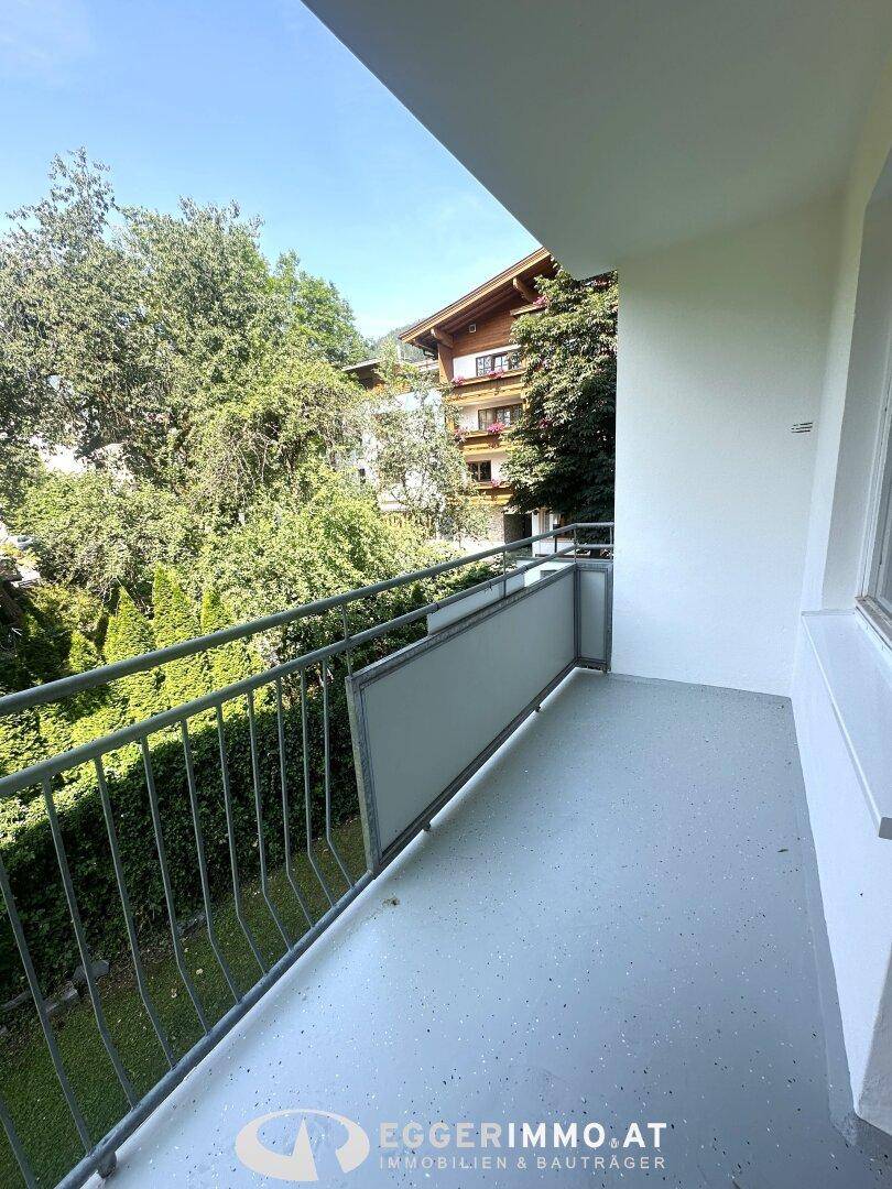 Geräumiger Balkon mit Blick auf üppige Bäume und die umliegende Bebauung.