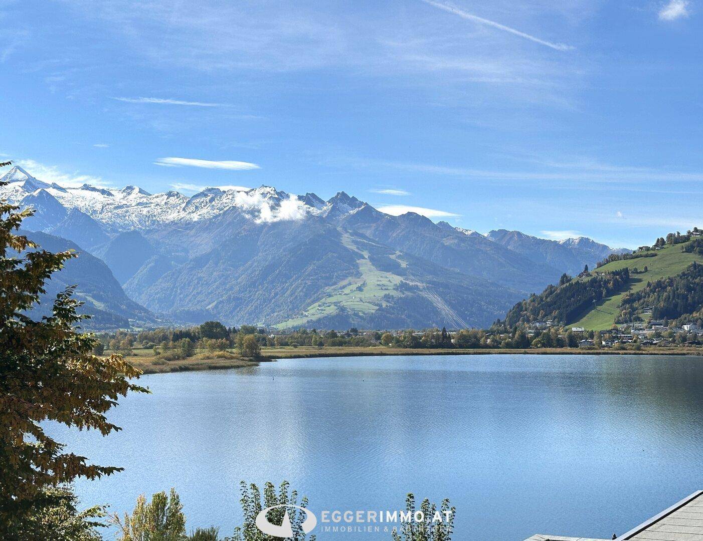 Panoramablick auf den See und die majestätischen Berge unter einem klaren blauen Himmel.