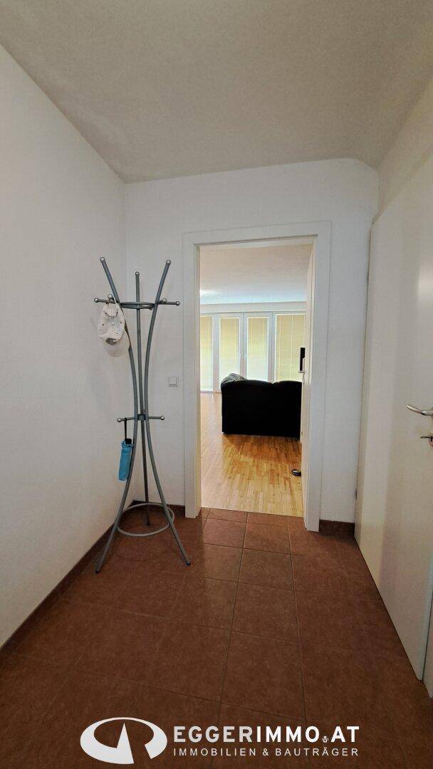 Eingangsbereich mit Fliesenboden und Garderobe, führt in den Wohnbereich.