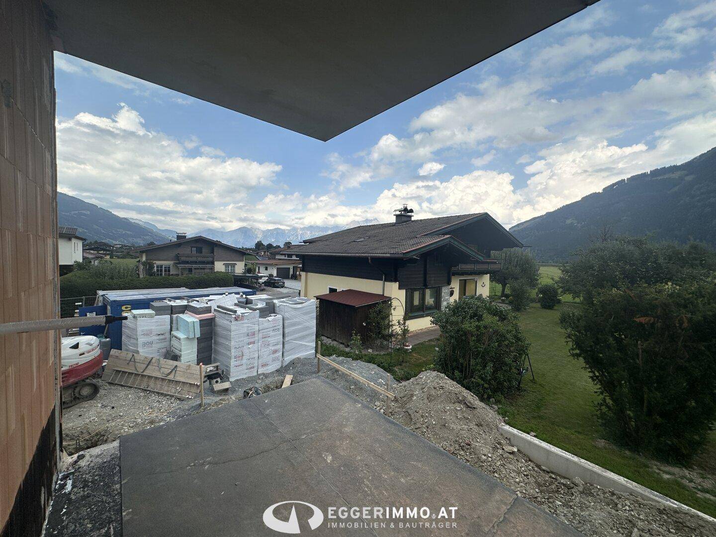 Unfertiger Balkonbereich im Bau mit Blick auf die umliegende Berglandschaft.