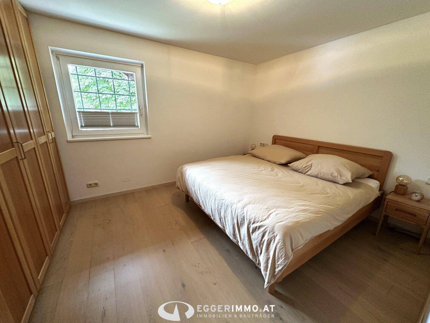 Gemütliches Schlafzimmer mit Holzbett, Einbauschränken und Parkettboden.