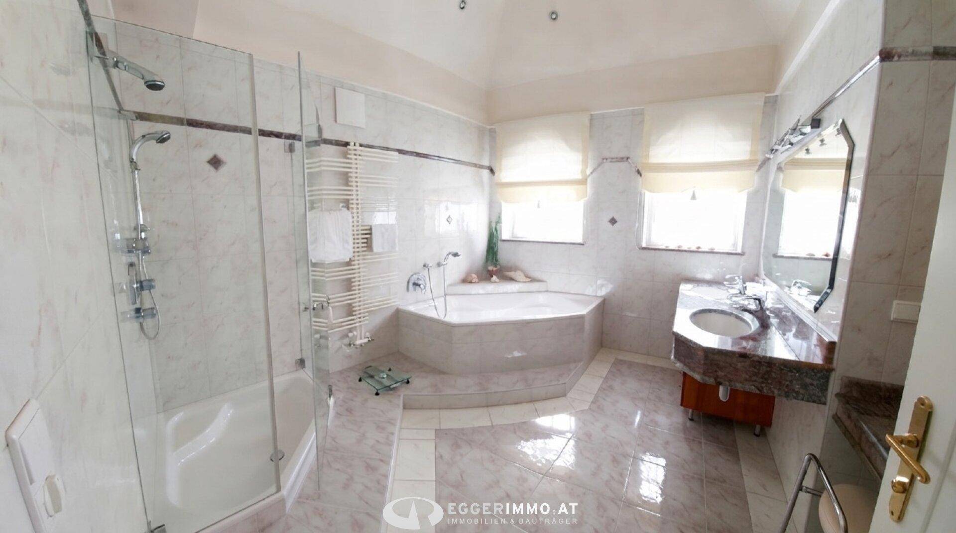Geräumiges Badezimmer mit Eckbadewanne, separater Dusche und doppelten Fenstern.