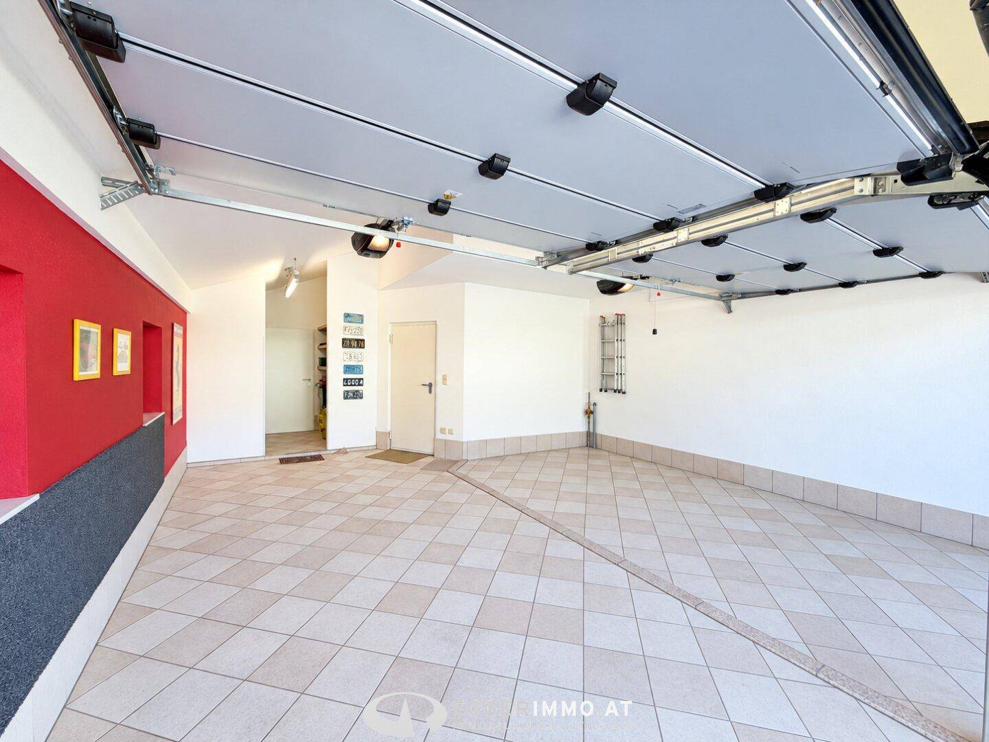 Geräumige Doppelgarage mit Fliesenboden und automatischen Toren.