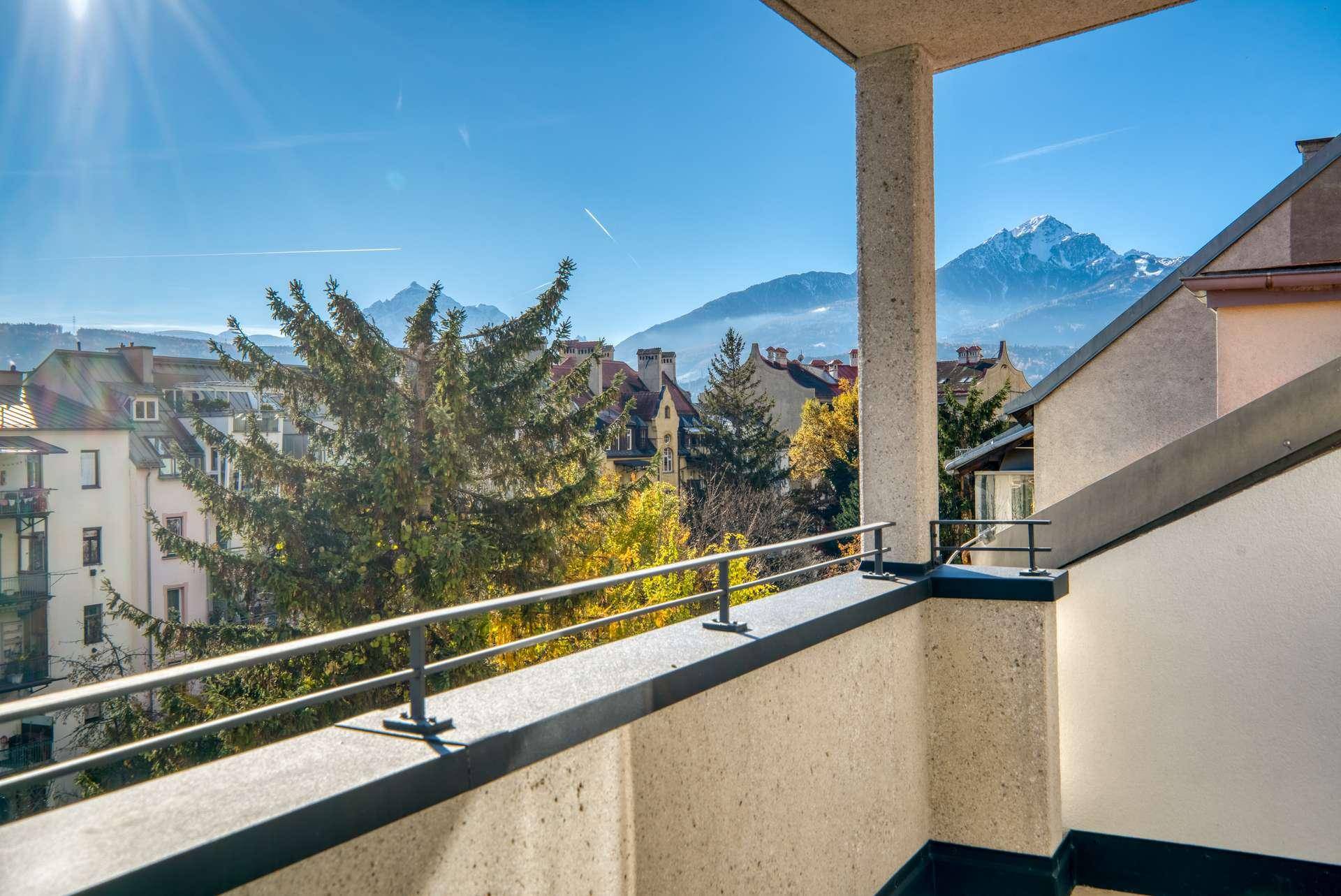 Sonniger Balkon mit atemberaubendem Panoramablick auf die Berge und die Stadt, ideal zum Entspannen.