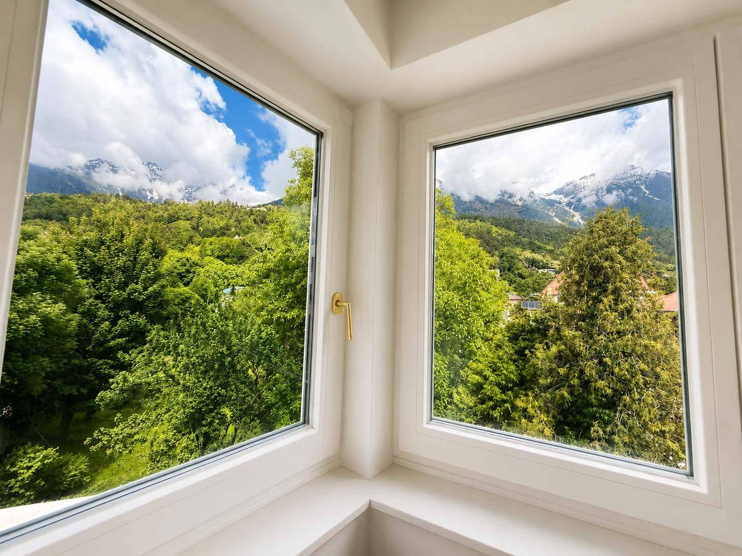 Große Fenster in der Ecke bieten einen atemberaubenden Blick auf die Berge und grüne Natur.