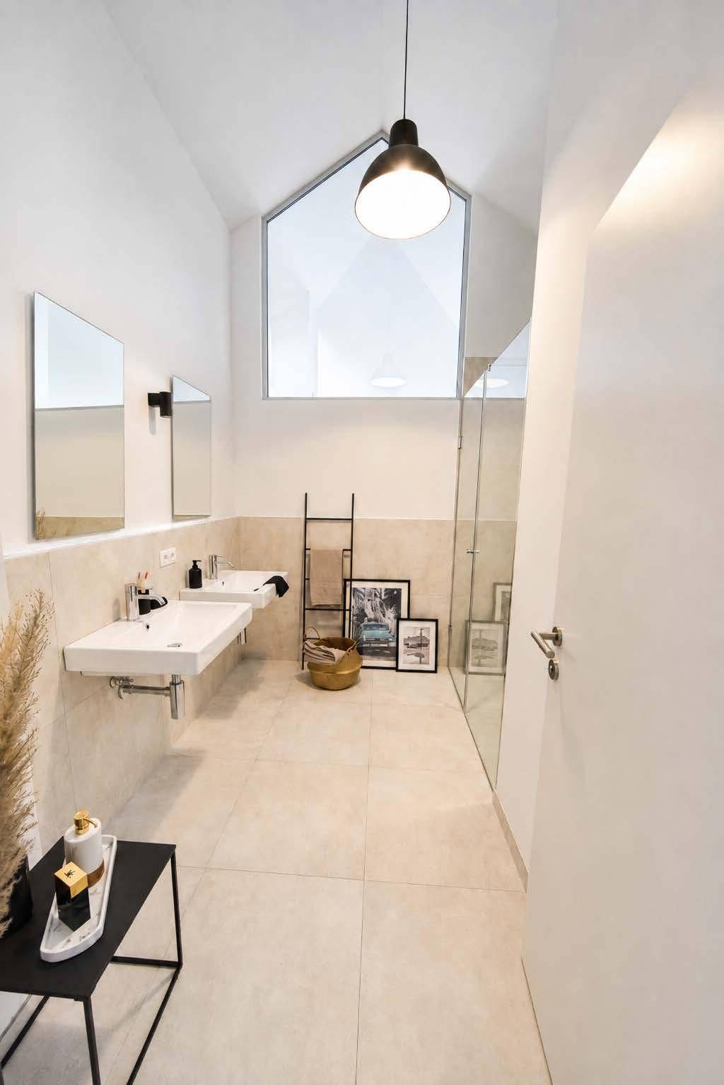 Modernes Badezimmer mit Doppelwaschbecken, begehbarer Dusche und hohen Decken.