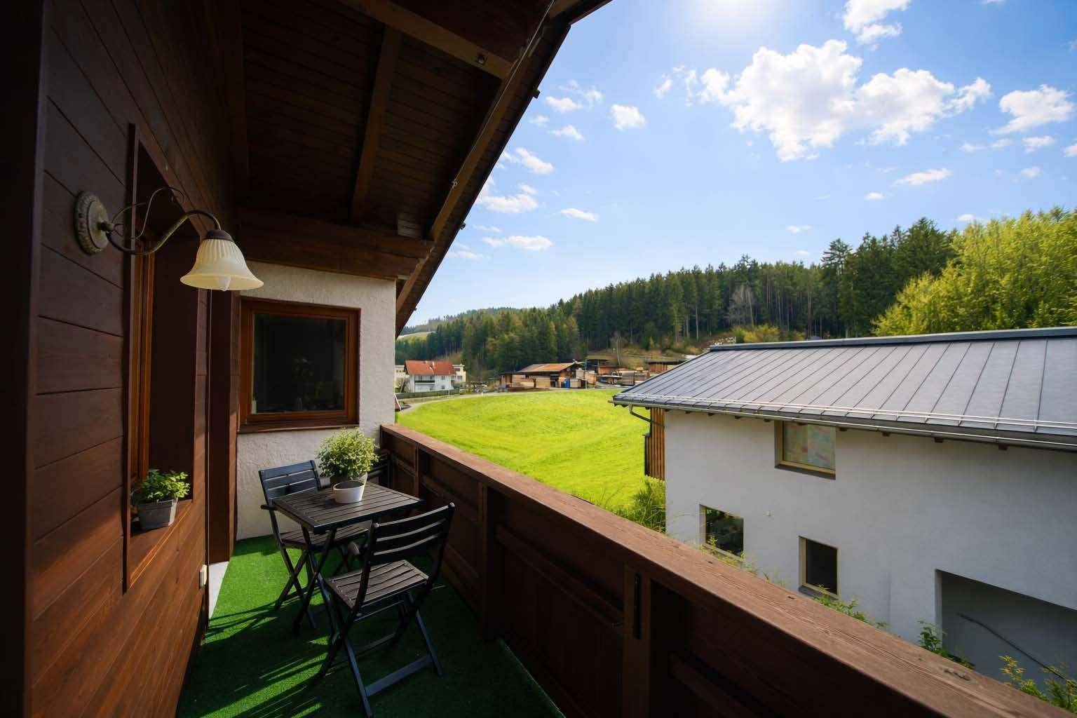 Gemütlicher Balkon mit Sitzgelegenheiten und weitem Blick über die grüne Landschaft.