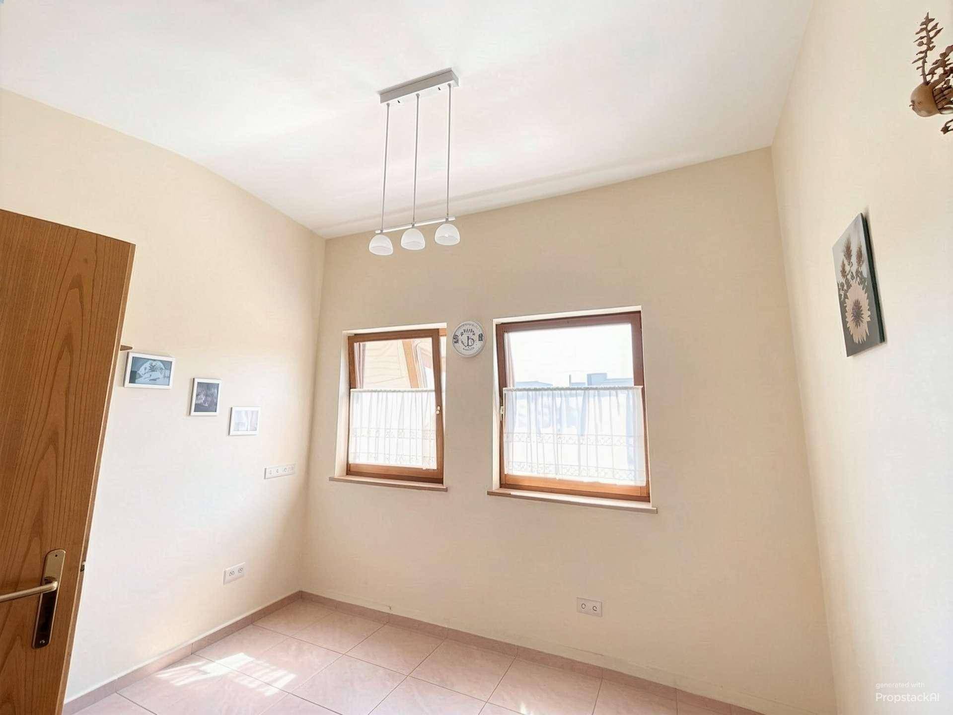 Helles Zimmer mit Fliesenboden und zwei Fenstern, ideal als Kinderzimmer oder Arbeitszimmer nutzbar.