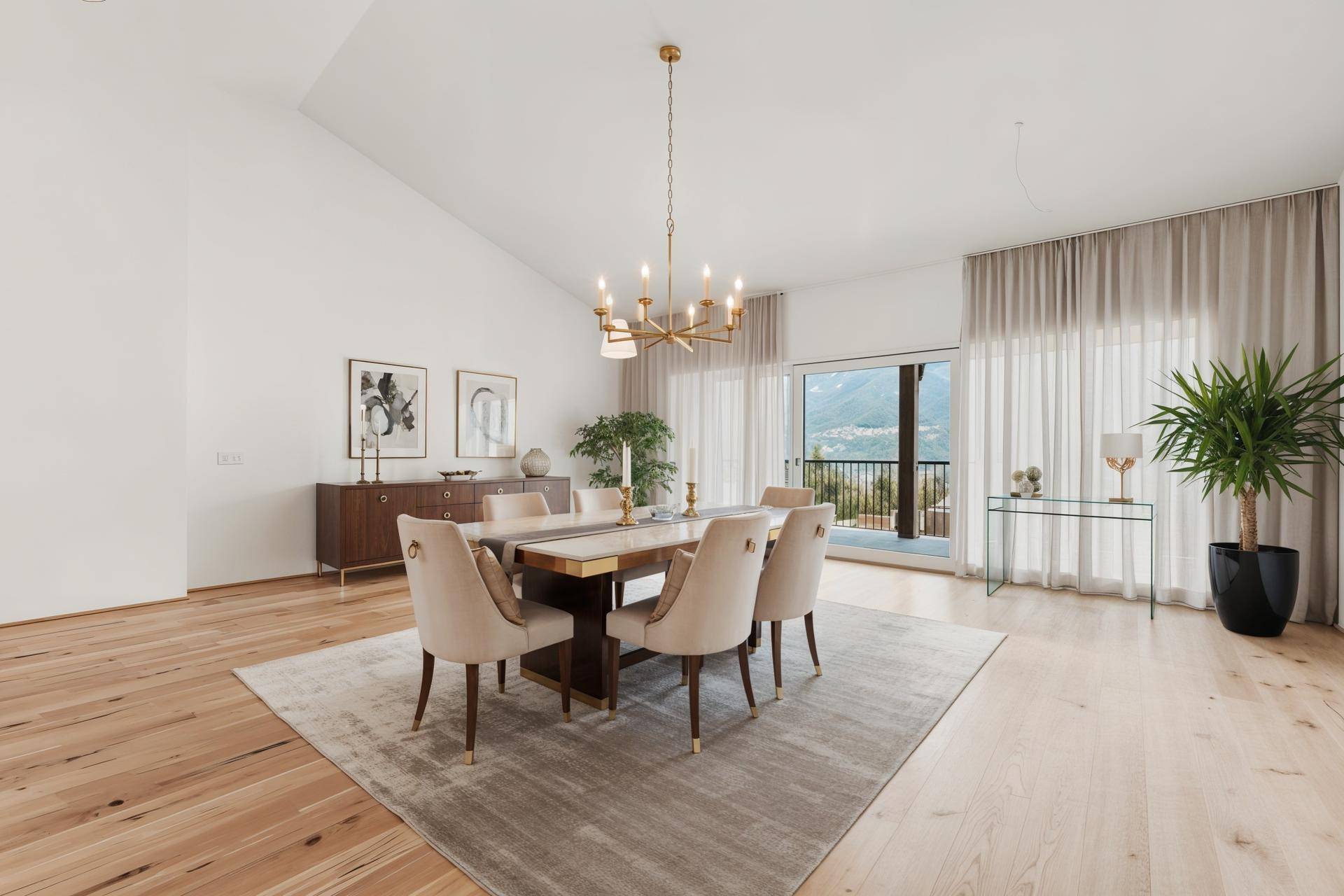 Eleganter Essbereich mit Holzboden, modernem Esstisch und Kronleuchter, mit Bergblick durch große Fenster.