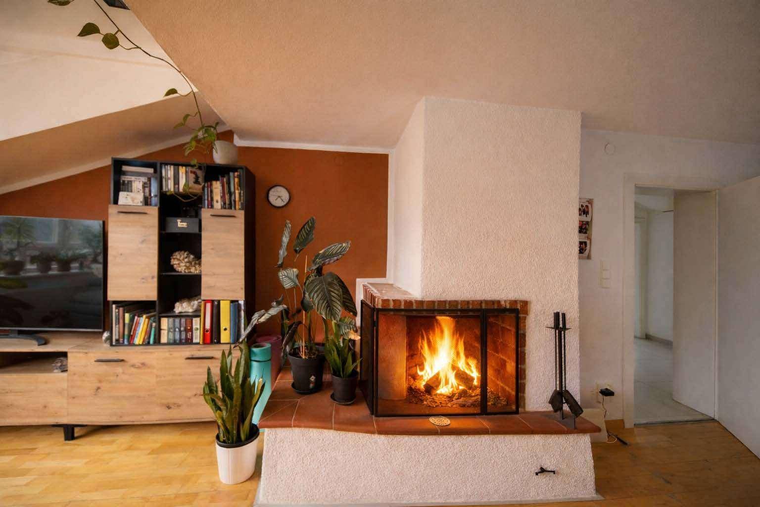 Wohnzimmer mit brennendem Kamin, Holzboden und rustikalem Charme für gemütliche Abende.