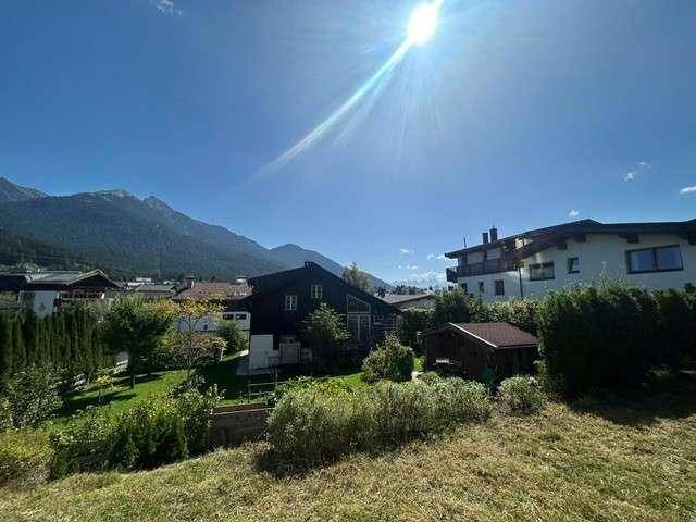Sonniger Außenbereich mit Blick auf die umliegende Wohngegend und die majestätischen Berge im Hintergrund.