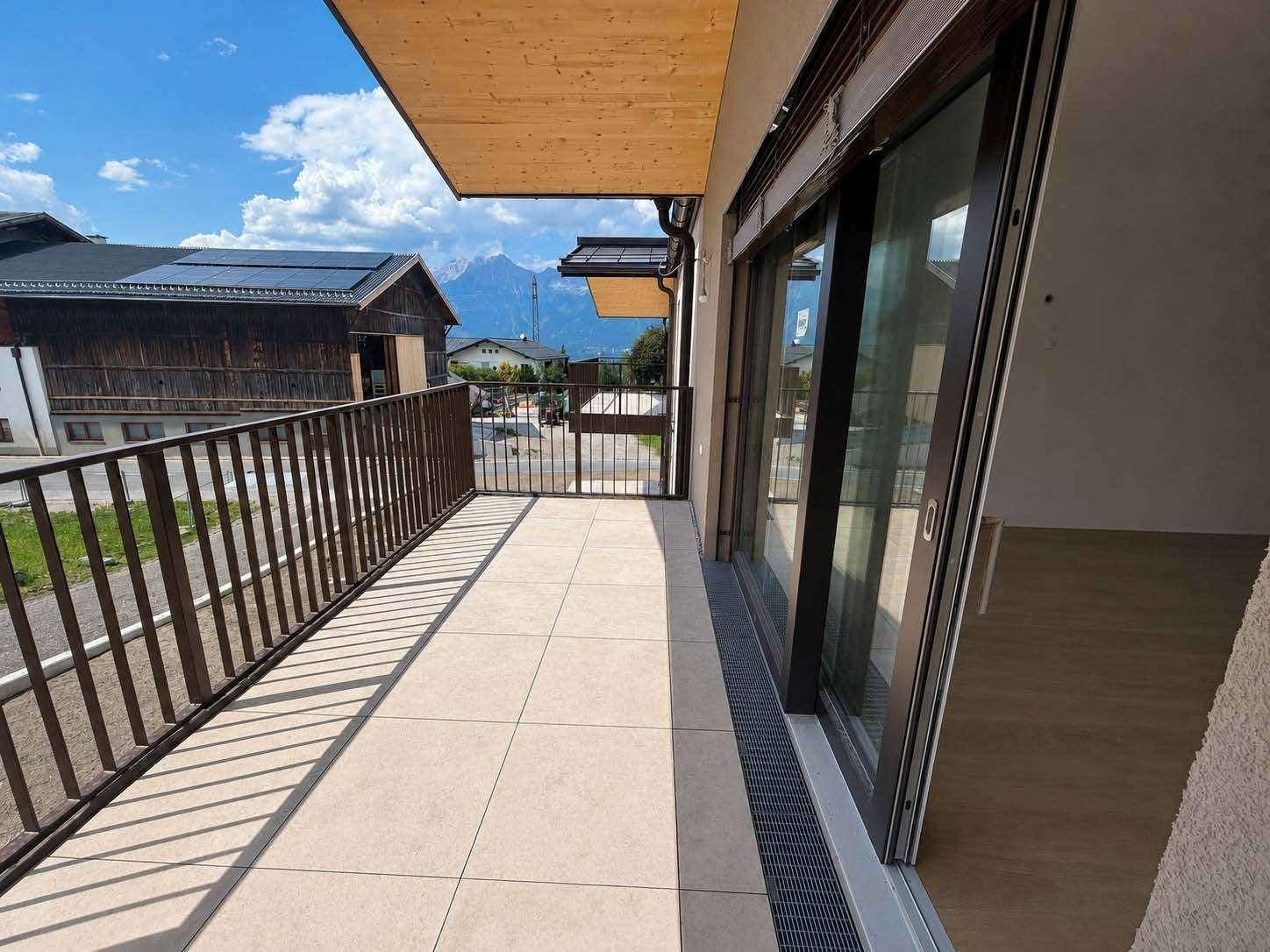 Geräumiger Balkon mit Fliesenboden und Bergblick, perfekt für Outdoor-Entspannung.